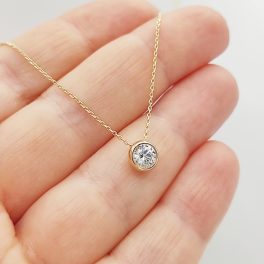 Sárga arany nyaklánc egy köves buttonos medállal